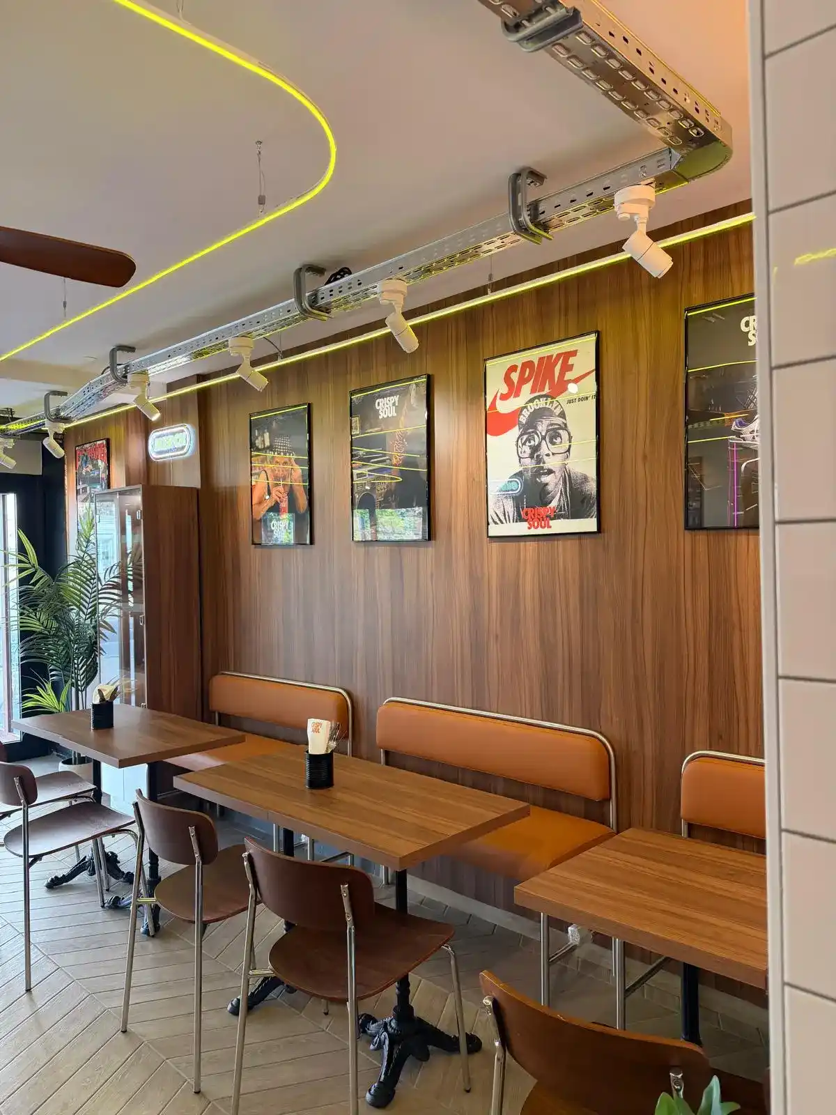 Salle d'un restaurant CRISPY SOUL : banquettes, bois et affiches culture US